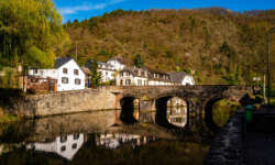 Eine Steinbrücke, die über einen ruhigen Fluss führt. Die alte Brücke
